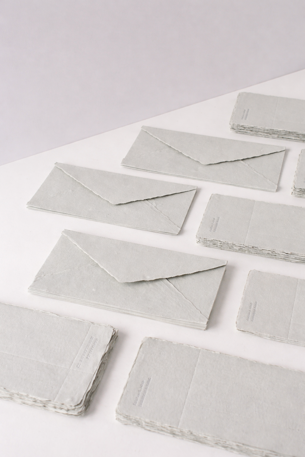 Hojas de papelería artesanal apiladas sobre una mesa de estudio